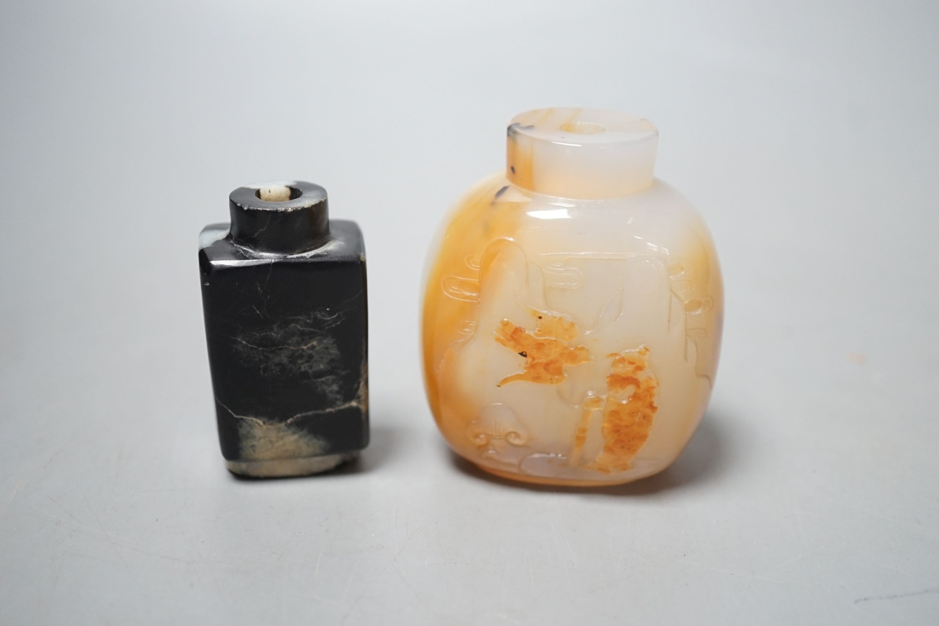 A Chinese white and black jade snuff bottle and a similar agate snuff bottle